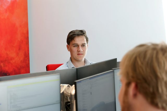 Colleague at work behind two monitors