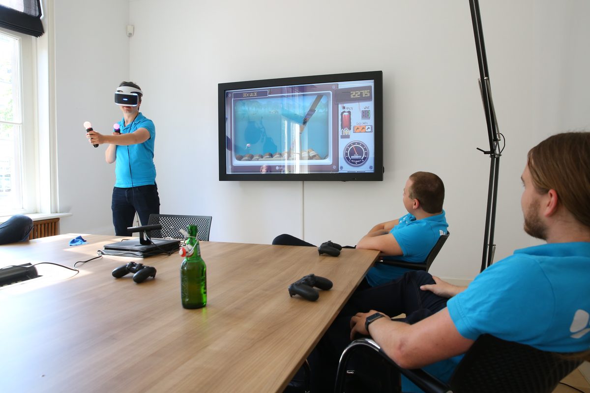 Colleague playing a VR game in the meeting room while others watch