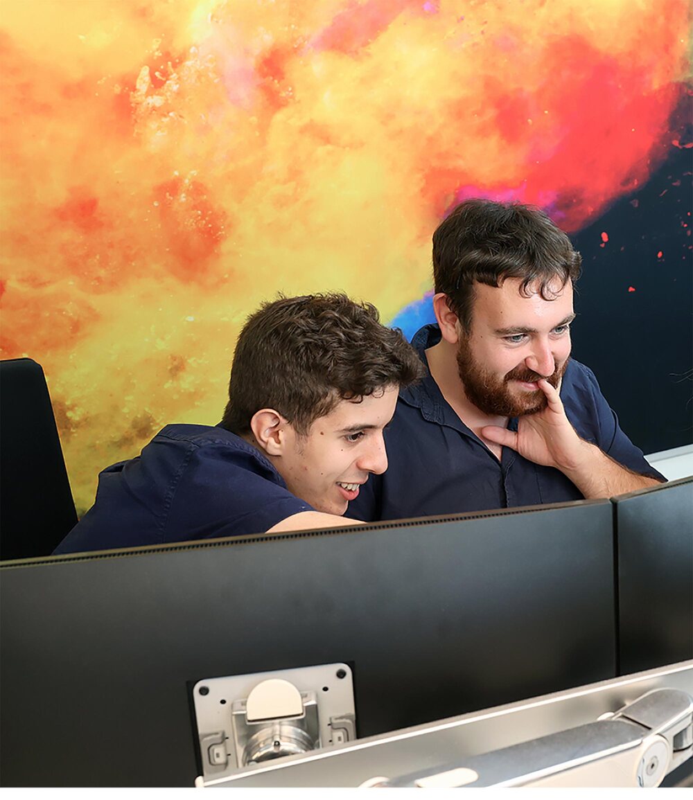 Two CleverMobi colleagues smiling at a screen